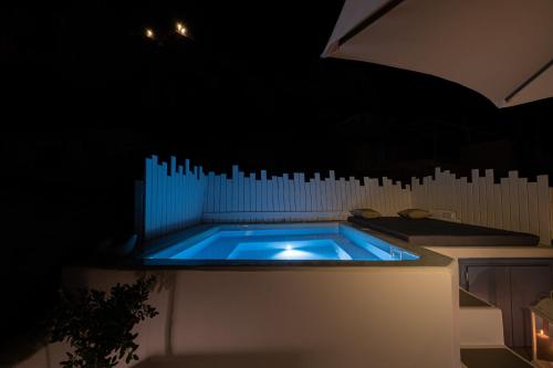 a blue hot tub in a room with a white fence at Santo Castello in Akrotiri