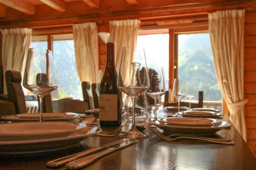 a table with glasses and a bottle of wine on it at Chalet Nido dell'Aquila in Sainte-Foy-Tarentaise