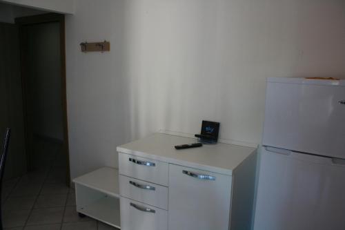 a kitchen with a white refrigerator and a phone on a counter at Residence Le Vele in Cattolica