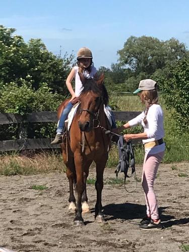 Une jeune fille faisant un cheval à côté d'une femme dans l'établissement Château de Saint-Agoulin, à Saint-Agoulin
