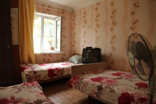 トゥアプセにあるzakhodi-ordokhniのベッド2台、窓、ファンが備わる客室です。