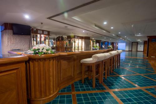 un bar avec une rangée de tabourets dans un pub dans l'établissement Suntara Wellness Resort & Hotel, à Chachoengsao