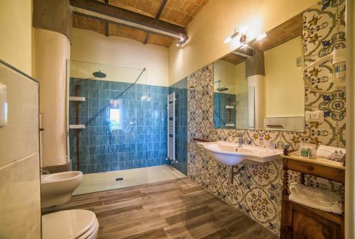 a bathroom with a sink and a toilet and a mirror at Agriturismo Podere Amati in Budrio