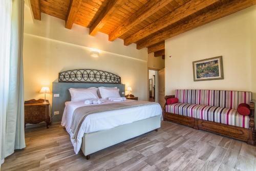 a bedroom with a large bed and a couch at Agriturismo Podere Amati in Budrio