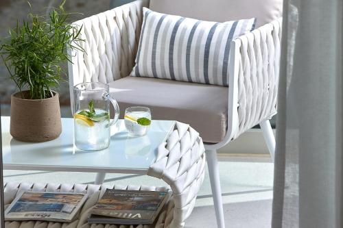 a white chair with a glass table and a glass table at Seafront Apartments by Myseasight in Hersonissos