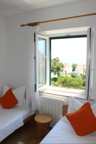 two beds in a room with a window at Apartments Marin in Bol