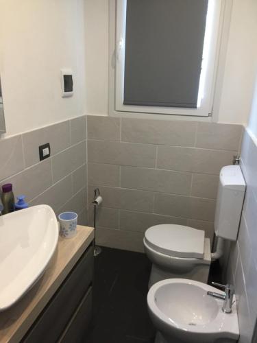 a bathroom with a white toilet and a sink at Casa Ninou in Domaso