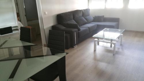 a living room with a couch and a table at Apartamentos La Vaguada Suites in Madrid