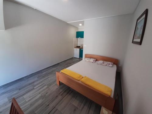a small bedroom with a bed and wooden floors at Apartments Dakovic in Kotor
