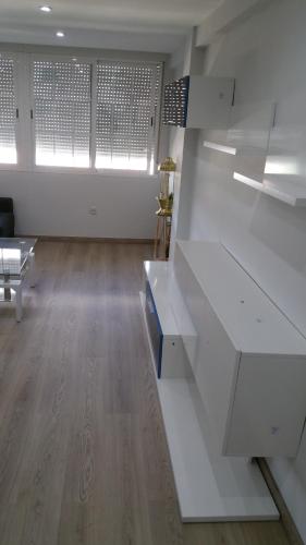 an empty room with white counters and a room with windows at Apartamentos La Vaguada Suites in Madrid