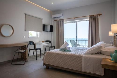 1 dormitorio con cama y vistas al océano en Euphoria Blue studio apartments en Loútsa