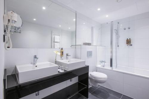 a bathroom with a sink, toilet and bathtub at Flemings Express Hotel Wuppertal in Wuppertal