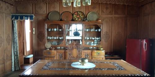 a dining room with a table and a red refrigerator at Maharaja palace houseboat in Srinagar
