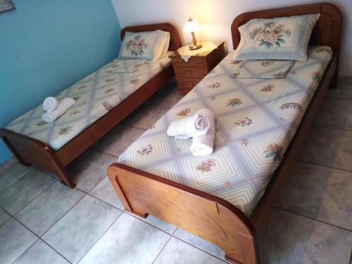 two twin beds in a small room with a lamp at 85 sqm Apartments New Panorama ELECTRIC CAR ΦΩΡΤΗΣΗΣ STATION in Paralion astros