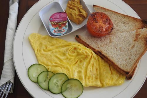 un plato con una tortilla y un huevo y un sándwich y un tomate en D'Batur Hotel, en Senggigi 