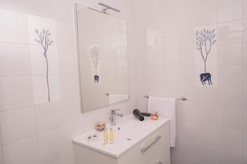a white bathroom with a sink and a mirror at Fuori le Mura in Paestum