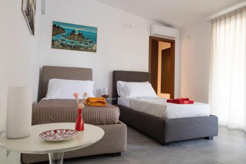 Zimmer mit 2 Betten, einem Tisch und einem Sofa in der Unterkunft Fuori le Mura in Paestum