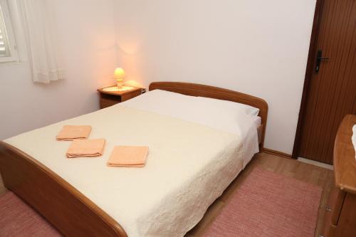 ein Schlafzimmer mit einem Bett mit zwei Handtüchern darauf in der Unterkunft Apartman Sardelić in Korčula