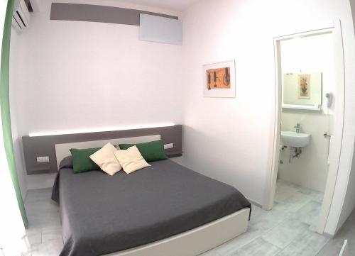 a small bedroom with a bed and a sink at Be Inn in Salerno