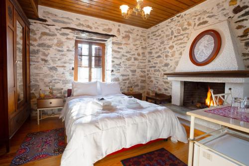 a bedroom with a large bed and a fireplace at Archontiko Montana in Vizitsa
