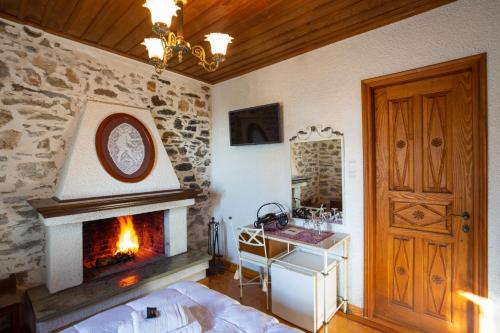 a living room with a fireplace and a bed and a door at Archontiko Montana in Vizitsa