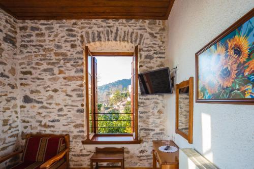 a room with a window in a stone wall at Archontiko Montana in Vizitsa