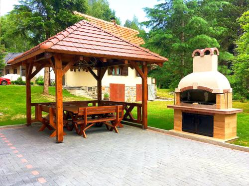 a pavilion with a picnic table and a pizza oven at Lovac apartmani in Zlatibor