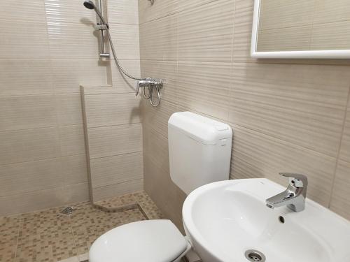 Un baño con un inodoro blanco y un lavabo. en Guest House Nova, en Mostar