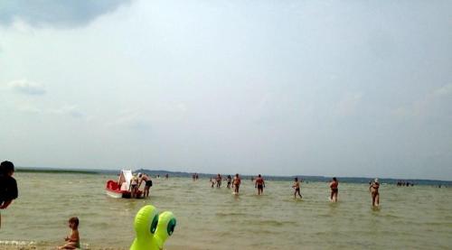a group of people on a beach with a boat in the water at Садиба For Rest in Svityazʼ