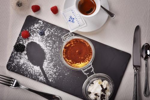 a table with a cup of coffee and a plate of food at Hotel Valtellina in Livigno