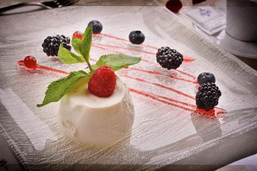 a dessert with strawberries and blackberries on a plate at Hotel Valtellina in Livigno