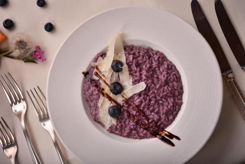 a white plate with a bowl of food on a table at Hotel Valtellina in Livigno