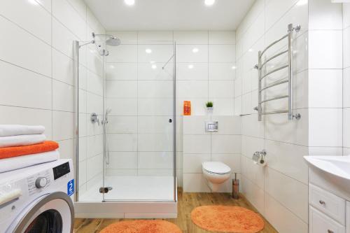 a bathroom with a shower and a washing machine at PaulMarie Apartments on Mayakovskogo 35 in Minsk