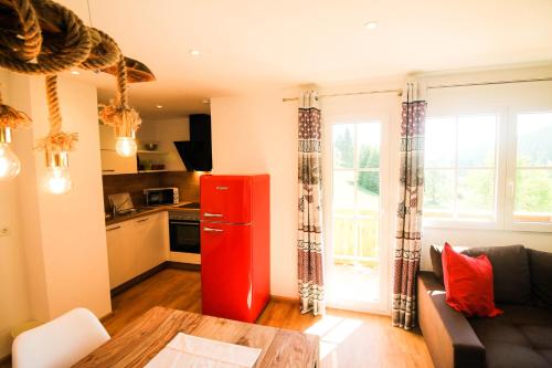 a kitchen with a red refrigerator in a living room at Black Forest Apartements by Hotel Grüner Baum Feldberg in Feldberg