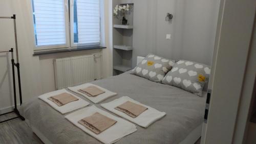ein Bett mit drei Kissen darauf in einem Schlafzimmer in der Unterkunft Apartament Białystok Center in Białystok