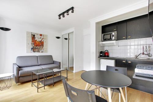 une cuisine et un salon avec une table et un canapé dans l'établissement Pick A Flat's Apartments in Batignolles - Rue Biot, à Paris