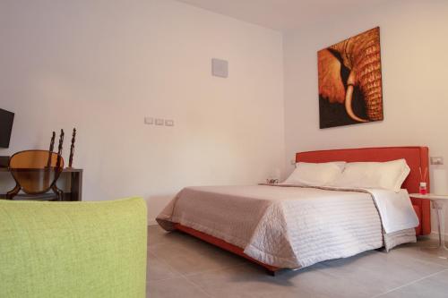 a bedroom with a bed and a green chair at Fuori le Mura in Paestum