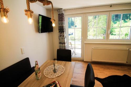 a living room with a dining room table and a window at Black Forest Apartements by Hotel Grüner Baum Feldberg in Feldberg
