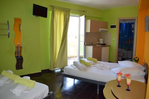 duas camas num quarto com paredes verdes em Lilalo Ηotel em Paralia Katerinis