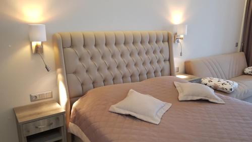 a bedroom with a large bed with two pillows on it at AKRON Luxury Holidays in Ancient Epidavros
