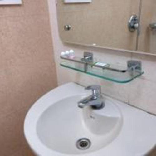 a bathroom with a white sink and a mirror at French Avenue in Kallāyi
