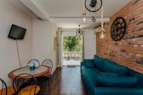 sala de estar con sofá azul y pared de ladrillo en Poolside Apartments Miljan i Ranko, en Herceg-Novi