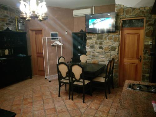 a dining room with a table and a tv on a stone wall at Apartments Old Isola in the center in Izola