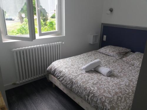 een bed met een kussen erop in een slaapkamer bij Cabareté Hotel in Capbreton