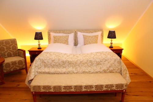 a bedroom with a bed with two lamps and a chair at Seehotel Grüner Baum in Hallstatt