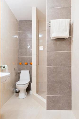 a white bathroom with a toilet and a sink at Hostel CENTRUM in Radom