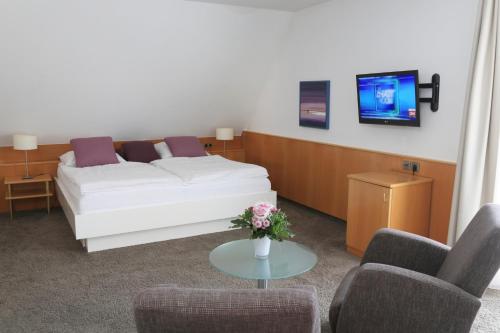 a living room with a white couch and two chairs at Landidyll Hotel Lamm in Vaihingen an der Enz