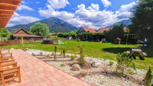 a garden with a playground and mountains in the background at Apartmany Centrum in Pavčina Lehota