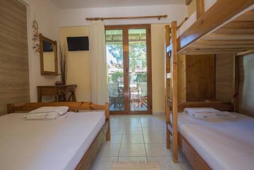 two bunk beds in a room with a balcony at Maria Village in Vourvourou