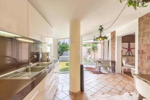 una cucina a pianta aperta con lavandino e un soggiorno di Stella Moresca Luxury Villa a Calasetta